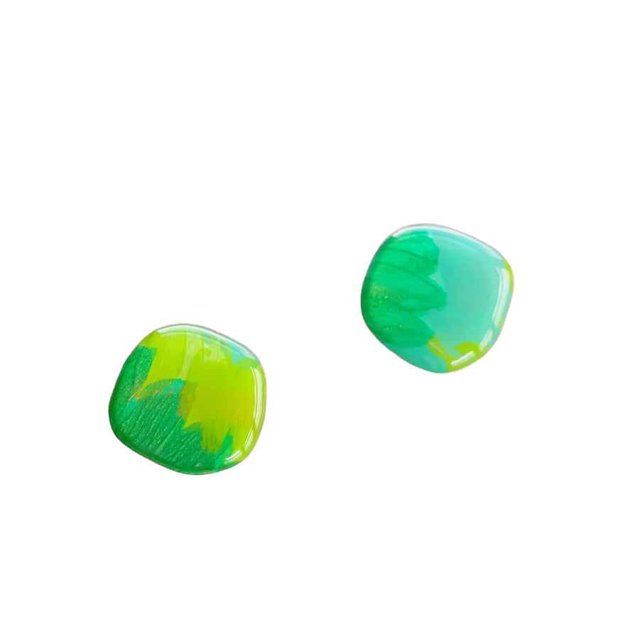 Two small green and turquoise tumbled stones with smooth, glossy surfaces. The stones exhibit a gradient of colors, blending green and turquoise hues with some yellow streaks. Positioned against a plain white background, they possess the same allure as Naoi's unique *Shades of Green Stud Earrings*.