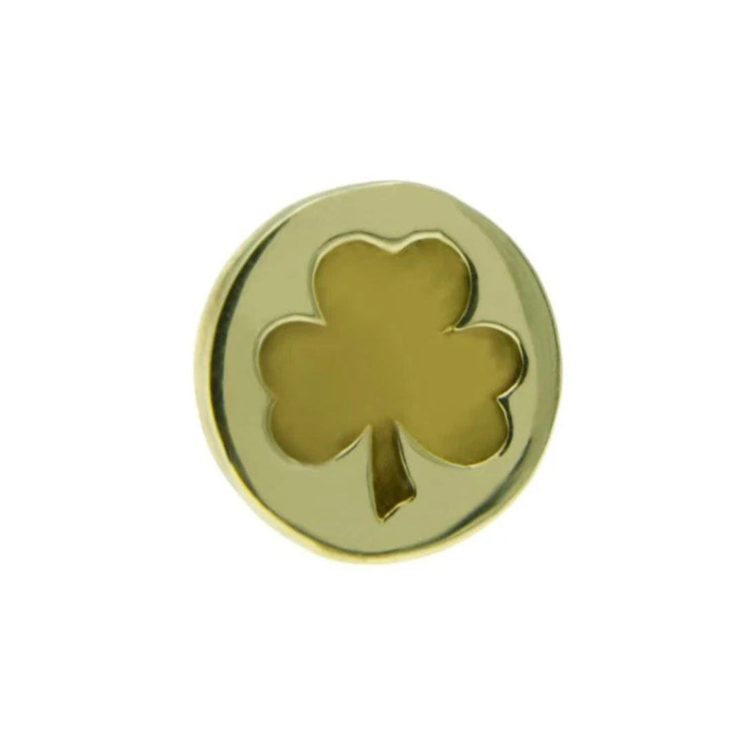 A Millett Wade Shamrock Lapel Pin is a circular gold pin featuring a cut-out shape of a three-leaf clover in the center. The clover design is symmetrical, and the polished surface with high-quality metal lacquer gives the solid brass lapel pin a shiny appearance.