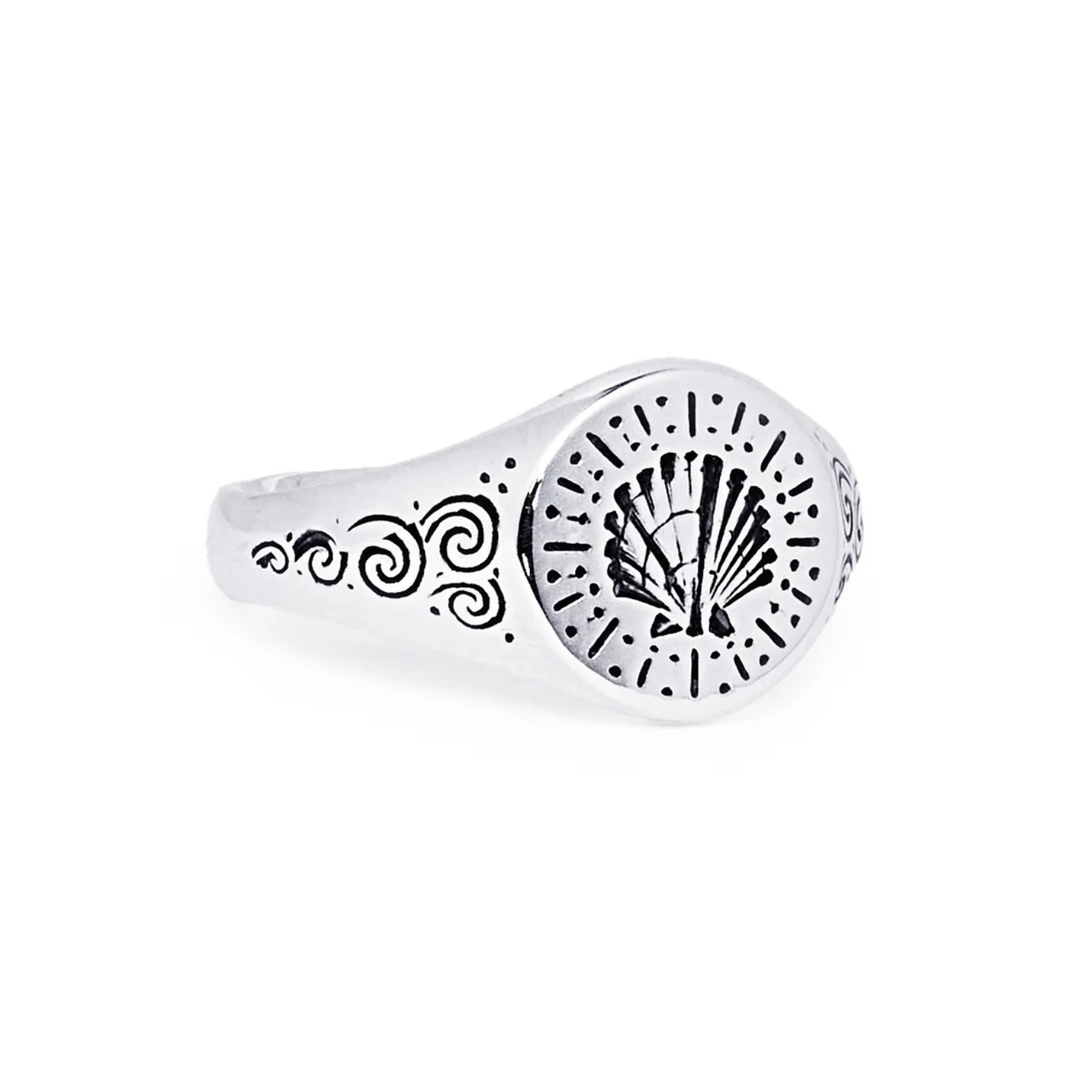 The Silver Sea Shell Signet by Cosmic Boulevard is a handmade engraved ring from Dublin featuring a central shell design with dotted and swirling patterns—ideal for custom engraving.