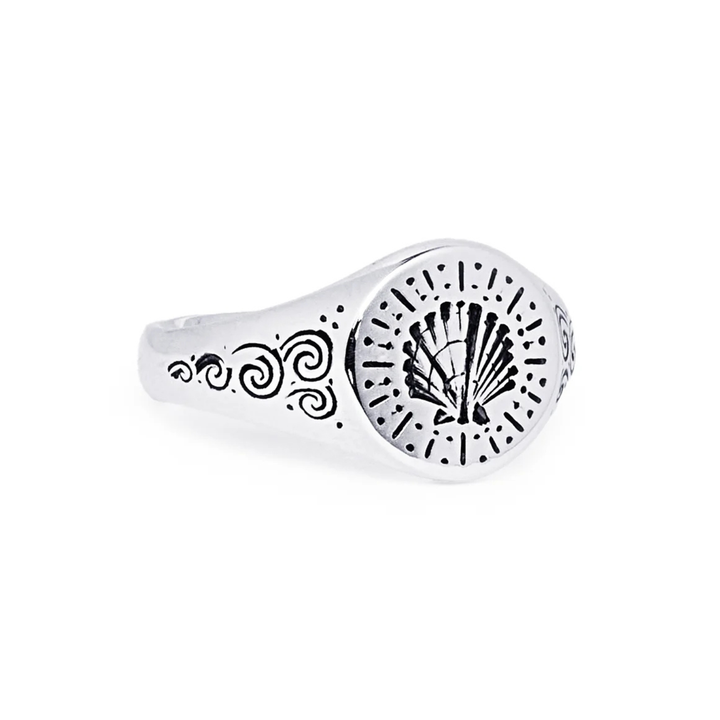 The Silver Sea Shell Signet by Cosmic Boulevard is a handmade engraved ring from Dublin featuring a central shell design with dotted and swirling patterns—ideal for custom engraving.