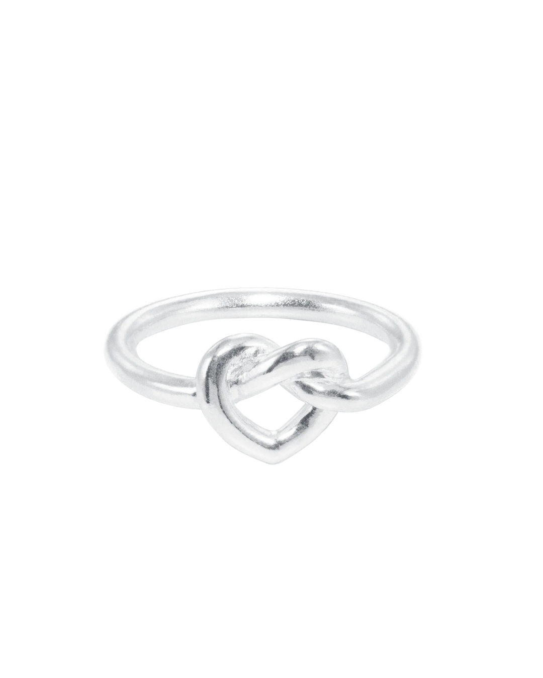 The Jane Koenig Tied Heart Ring is a simple sterling silver ring featuring a heart-shaped knot at the center, shown on a plain white background.