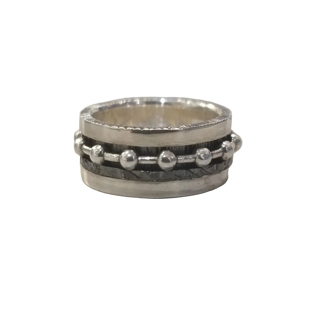 The K.And Silver Double Spinner Ring with Balls features a sterling silver band with a dark oxidised textured center and a row of small silver beads, shown on a light gray surface.