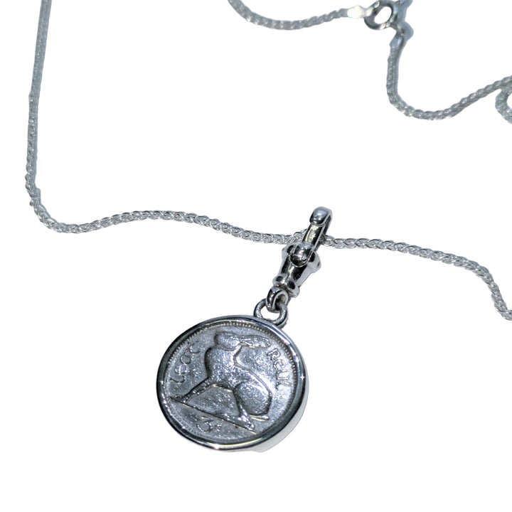 Silver necklace with a round pendant on a light gray background