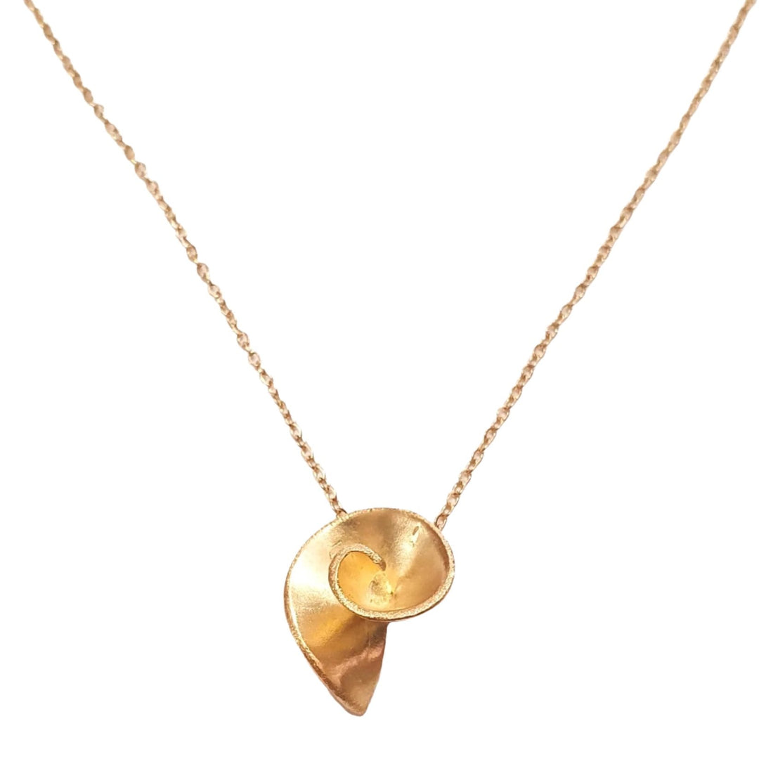 A delicate gold-plated necklace featuring a pendant with an abstract, spiral design resembling a seashell. The chain is thin and elegant, holding the unique Small Swirl Pendant by Georgia Charal at its center. The background is a plain, light surface.