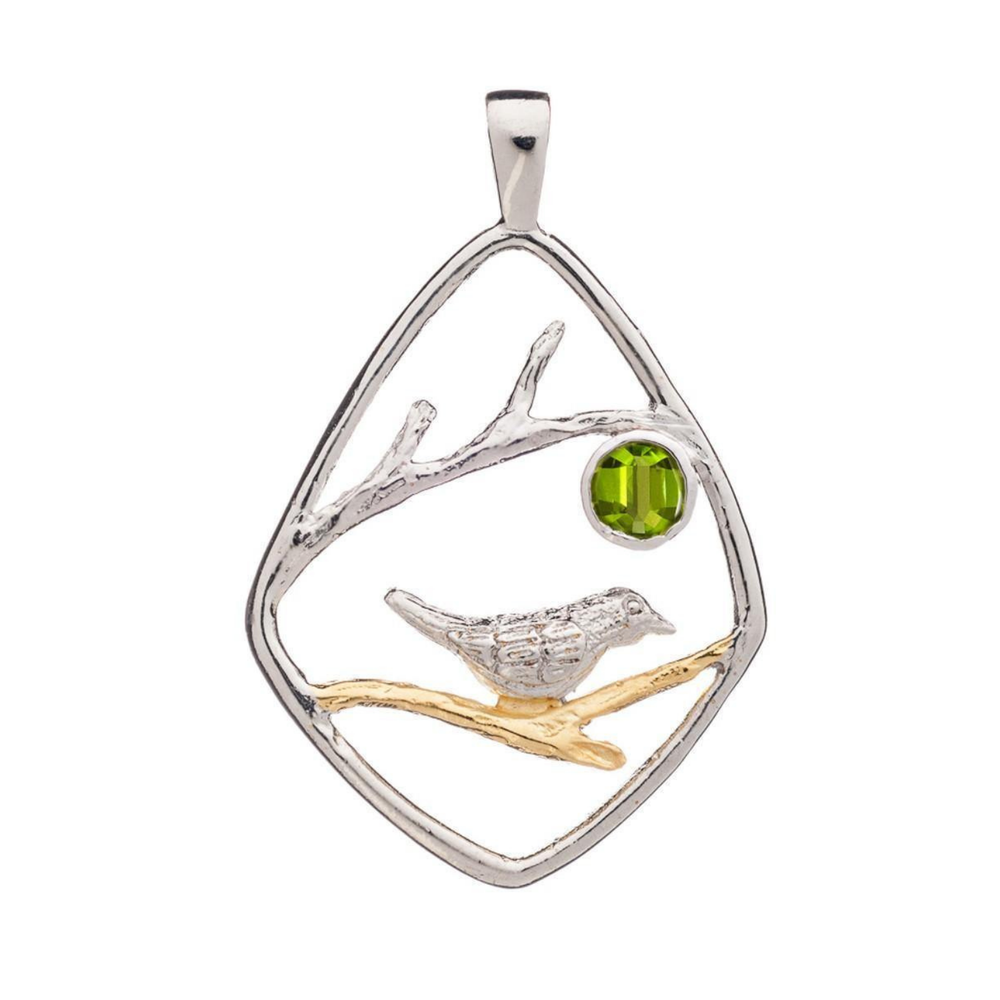 An elegant Song Bird Pendant by Gallardo & Blaine Designs featuring a song bird perched on a golden branch within a diamond-shaped sterling silver frame. A green gemstone is set inside, depicting a sun or moon. Delicate branches extend across the design, adding to the intricate detail.