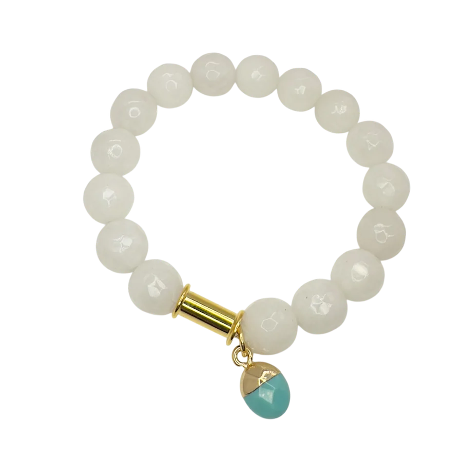 The Soulstone White Agate and Turquoise Bracelet by Aria V features glossy white agate beads, a gold accent, and a turquoise charm, all handmade in Dublin and elegantly displayed on a white background.