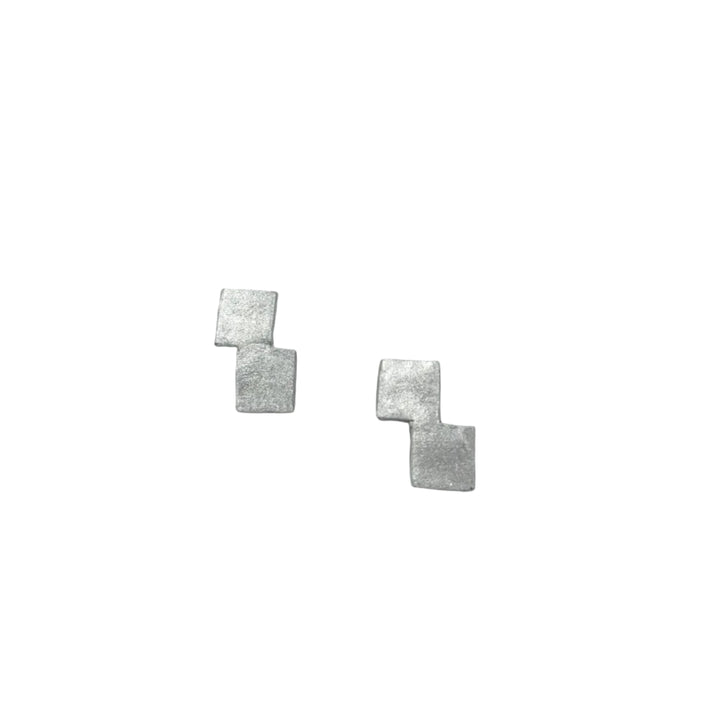 The Stairway to Heaven Earrings - Small by Soufana Attia are minimalist silver earrings with two asymmetrically connected, overlapping square shapes, shown on a plain light grey background.