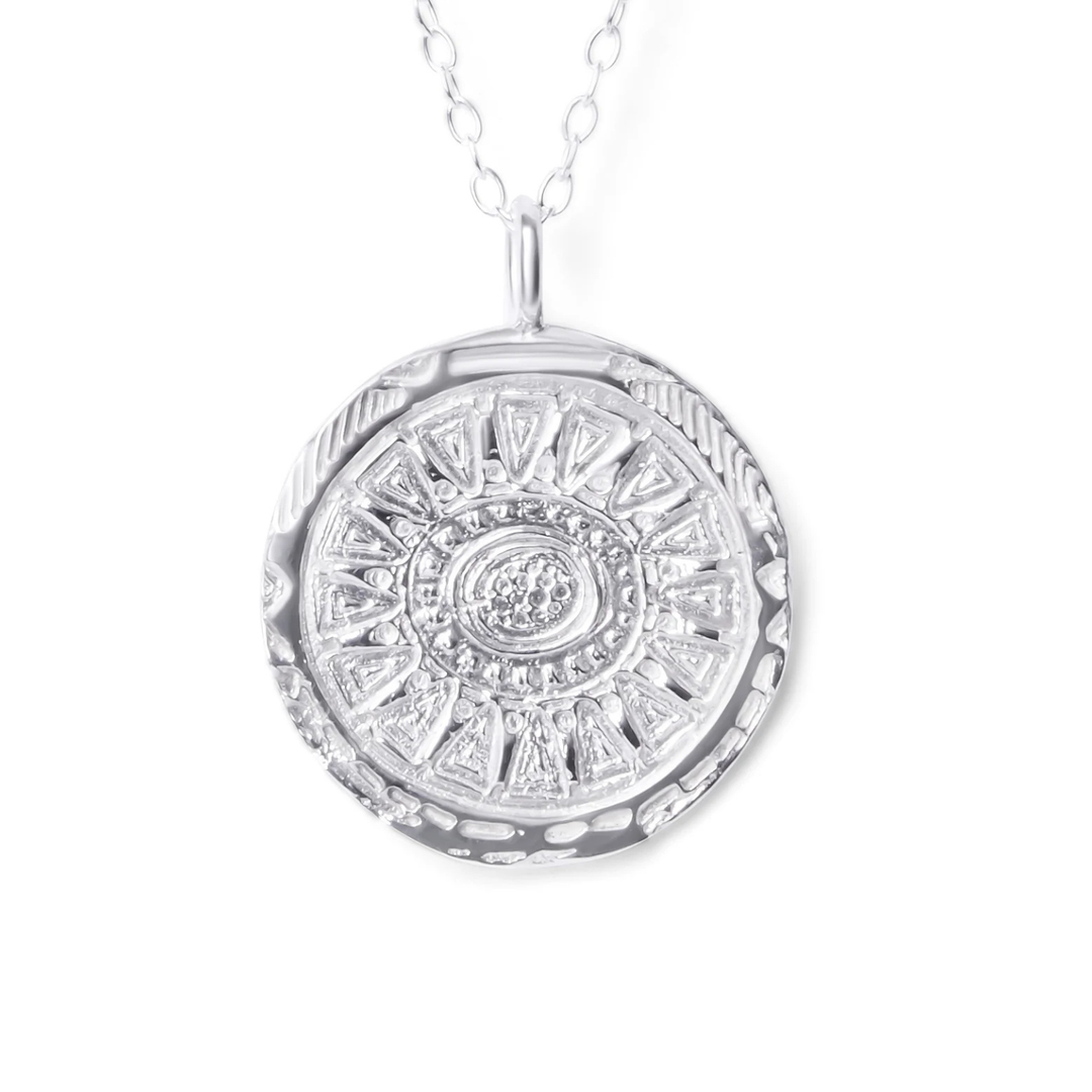 The Sunbeam Pendant Silver by Ava Jane Jewellery is a sterling silver necklace with a textured, round medallion featuring intricate geometric patterns on a delicate chain—an elegant, gift-ready accessory for any occasion.