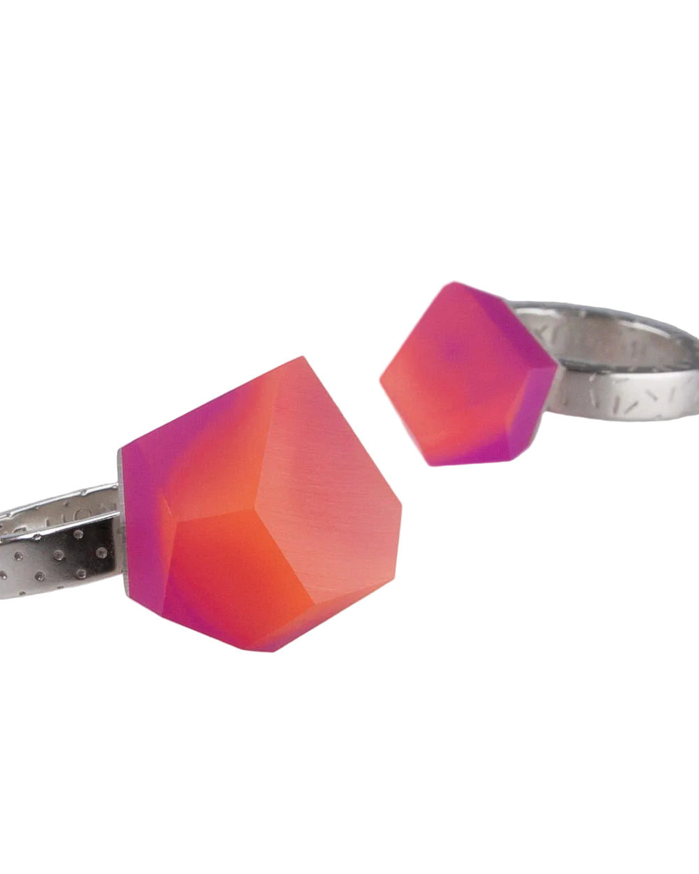 Two silver Fruit Bijoux Ring Top VU Crystals Sunset Pink by Fruit Bijoux showcase geometric, faceted resin stones in a gradient of pink, orange, and purple hues against a white background.