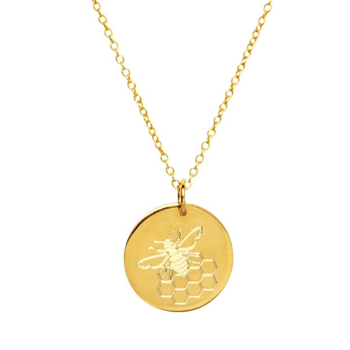 The Symbol Necklace in 9k Gold by Personalised Charms features a round gold disc engraved with a bee and honeycomb pattern, hanging from a delicate gold chain.
