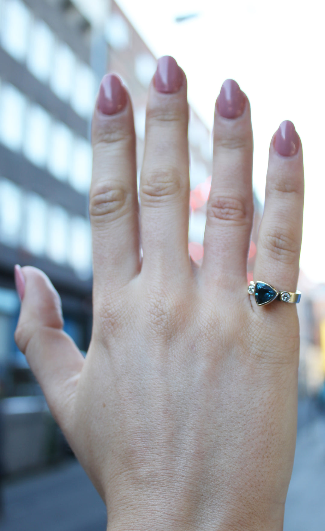 9ct yellow gold ring with triangular blue tourmaline in the centre and round diamond on either side set in 9ct yellow gold 9ct yellow gold band is 4 mm wide. Shown tried on, on a pinky finger