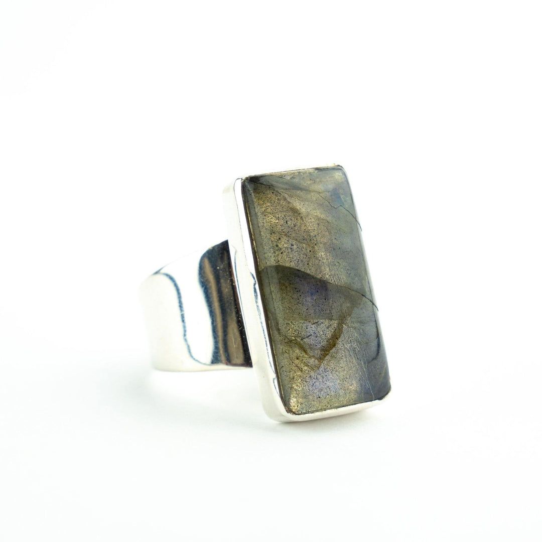 A Watermelon tropical Silver Rectangle Labradorite Ring featuring a wide band with a rectangular labradorite gemstone. The stone has a polished surface with subtle iridescent blue and green flashes, set in a bezel setting. The ring is positioned against a plain white background.