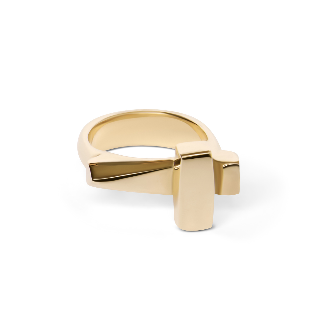 The Totem Ring by Madeleine Sculptural Jewellery features a bold, intersecting cross design in gold. This handmade statement piece is artfully showcased on a white background.