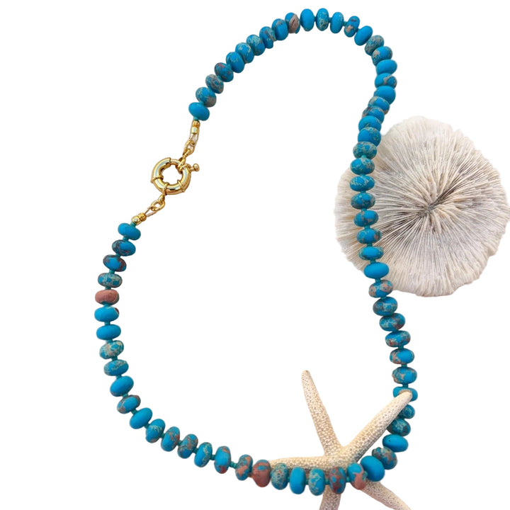 Turquoise candy bead necklace on white background
