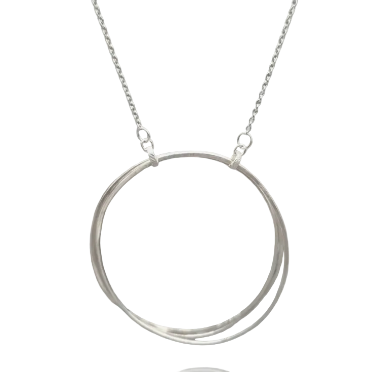 A silver necklace featuring a double-ring pendant, with one larger polished ring and one smaller twisted ring, suspended from a delicate cable chain against a solid gray background.