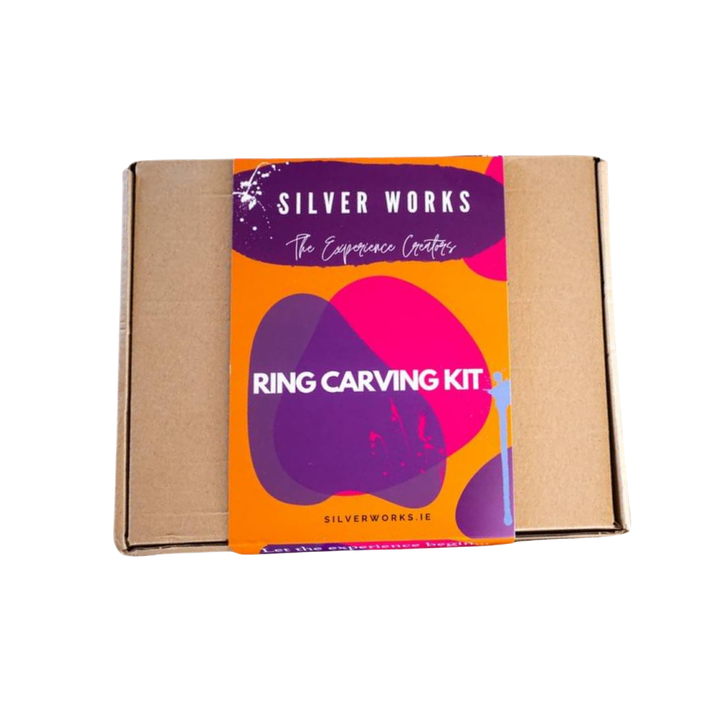 A brown cardboard box wrapped in a colorful sleeve labeled “Silver Works - Ring Carving Kit.”.