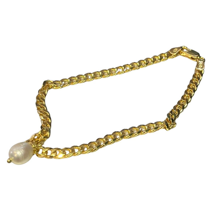 The Perla Anklet Gold by Bonvo is a sterling silver chain bracelet with an intricate link design, featuring a single round pearl pendant in the center. The bracelet has a clasp fastening on one end. The overall design is elegant and delicate.