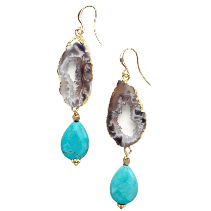 A pair of handcrafted Cameo Earrings by Aria V featuring intricate designs. The top part is made from a textured, raw-cut stone in shades of white, gray, and brown. Attached below are turquoise teardrops with gold accents and hooks, highlighting the beauty of natural stones.