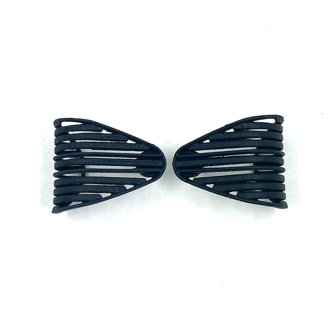 Two black, plastic hair clips with wide, slotted designs are laid out on a white background, facing each other symmetrically, creating a mirrored appearance. Their sleek design is reminiscent of modern Vibe Grill Earrings by Elsiem paired with sterling silver ear posts.