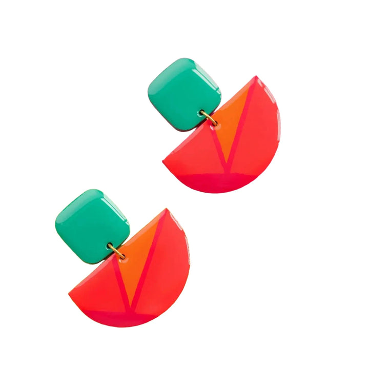 A pair of Naoi Vivid Statement Earrings on a white background. Each earring features a green square at the top and a red semicircle with a pink geometric pattern dangling below. These wooden pendant earrings boast a fun and vibrant design.