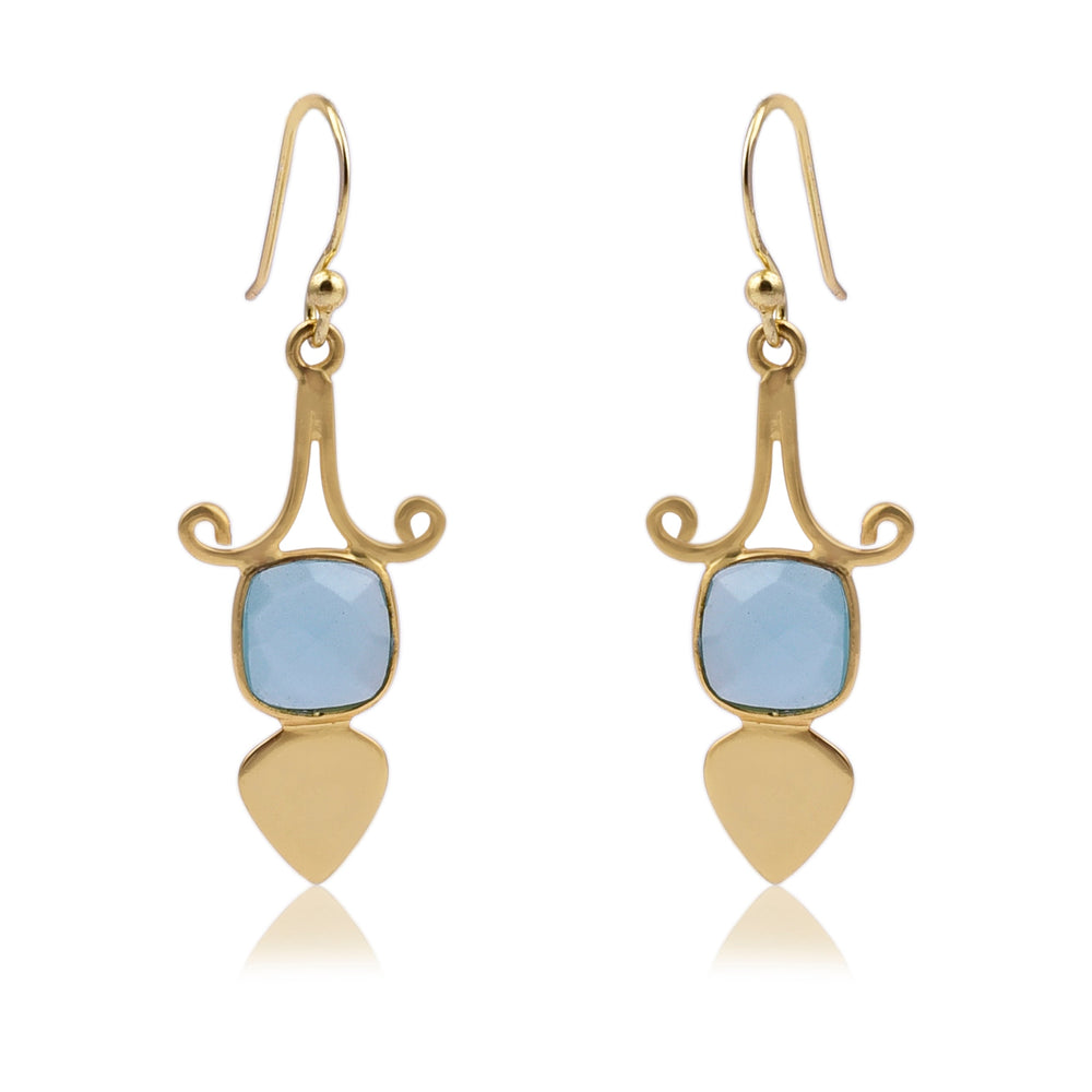 A pair of elegant Gold Shield Aqua Chalcedony Earrings by Watermelon Tropical featuring a curved design at the top, with a square blue gemstone in the center, and ending with a teardrop-shaped gold piece at the bottom. These exquisite pieces of handmade jewellery have hook closures.