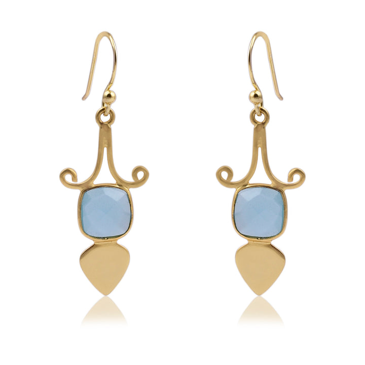 A pair of elegant Gold Shield Aqua Chalcedony Earrings by Watermelon Tropical featuring a curved design at the top, with a square blue gemstone in the center, and ending with a teardrop-shaped gold piece at the bottom. These exquisite pieces of handmade jewellery have hook closures.