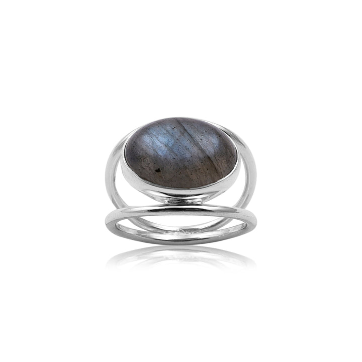 A close-up image of a Double Silver Band Labradorite Ring by Watermelon Tropical featuring an oval-shaped gray and iridescent labradorite stone. The handmade jewellery piece has an open, modern design with a double band that joins at the top and bottom, framing the central labradorite perfectly.