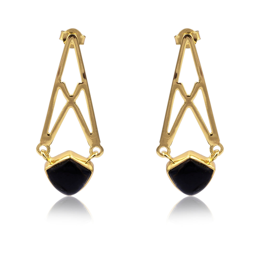 A pair of Petersite Gold Crossed Earrings featuring intricately designed triangular shapes with an open framework. At the bottom of each earring is a black, shield-shaped Petersite gemstone, providing a striking contrast to the gold metal. The handmade jewellery earrings by Watermelon Tropical are set against a white background.