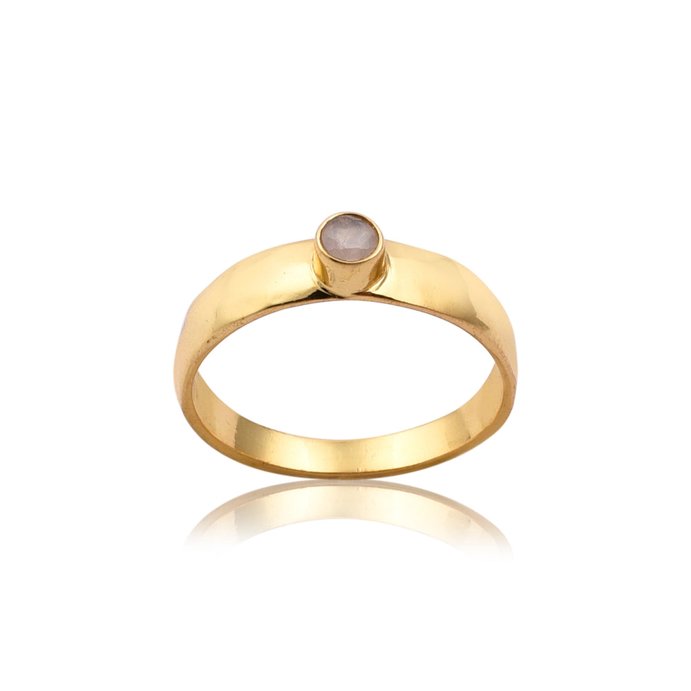 A **Solo Moonstone Gold Band Ring** by **Watermelon Tropical** with a simple band design featuring a single, round moonstone set in a raised bezel. The shiny gold band is smooth and polished, reflecting light. This piece of handmade jewellery is displayed against a white background with a subtle reflection below it.