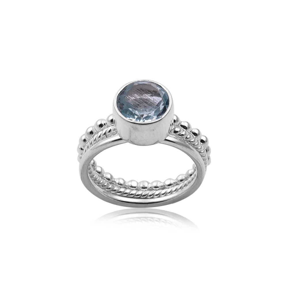 A Watermelon tropical Triple Stacking Blue Topaz Silver Ring with intricate detailing on the band and a round Blue Topaz gemstone set in a simple bezel setting. The ring features bead-like accents and twisted patterns along the band, exemplifying handmade jewellery craftsmanship. The image showcases the ring against a white background.