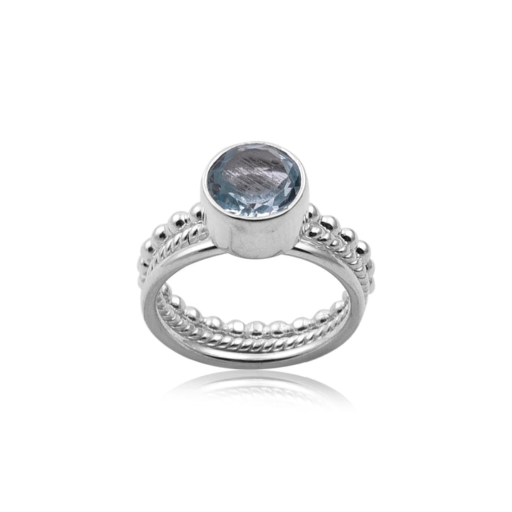 A Watermelon tropical Triple Stacking Blue Topaz Silver Ring with intricate detailing on the band and a round Blue Topaz gemstone set in a simple bezel setting. The ring features bead-like accents and twisted patterns along the band, exemplifying handmade jewellery craftsmanship. The image showcases the ring against a white background.