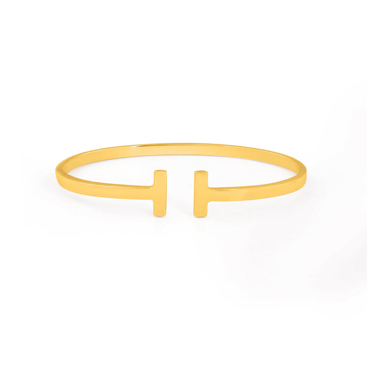 A minimalist gold vermeil bracelet with an open-ended design featuring two flat, symmetrical bar shapes at each end, facing each other. This sleek and polished Holly Bangle by Watermelon Tropical rests elegantly on a plain white background.