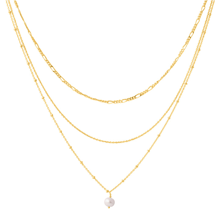 The Carmen necklace by Watermelon Tropical features three delicate gold vermeil chain layers. The shortest chain sits near the collarbone, followed by a slightly longer second chain. The longest chain holds a small, dangling white pearl pendant, adding a touch of elegance to this beautiful triple-layered piece available in various gemstones.