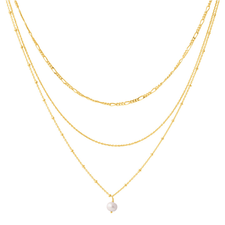 The Carmen necklace by Watermelon Tropical features an elegant triple-chain design, artfully incorporating layers of varying lengths. The shortest chain showcases a delicate white pearl pendant, while the other two chains are composed of refined gold links. This versatile layered gold vermeil necklace exudes sophistication and style.