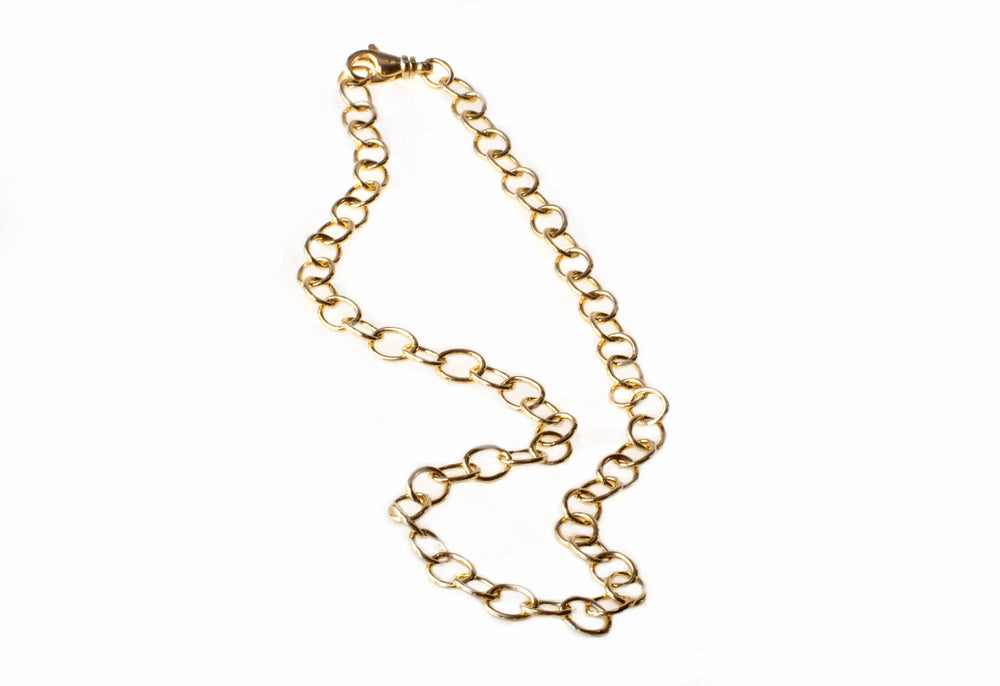 A handcrafted Wide Anchor Chain by Detlef Menard is laid out on a white background. The chain consists of large, oval-shaped links connected in a continuous pattern, giving a shiny and elegant appearance.