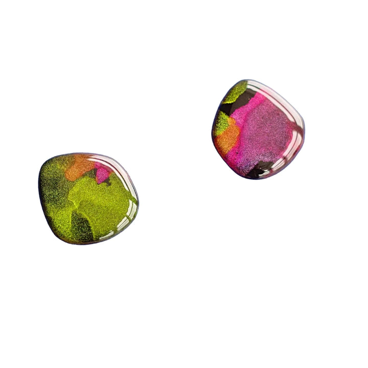 Two small, glossy, irregularly-shaped stones with a polished finish. Each stone features a vibrant, abstract mix of green, pink, orange, and purple colors. These unique "Aurora Stud Earrings" by Naoi are set against a plain white background.