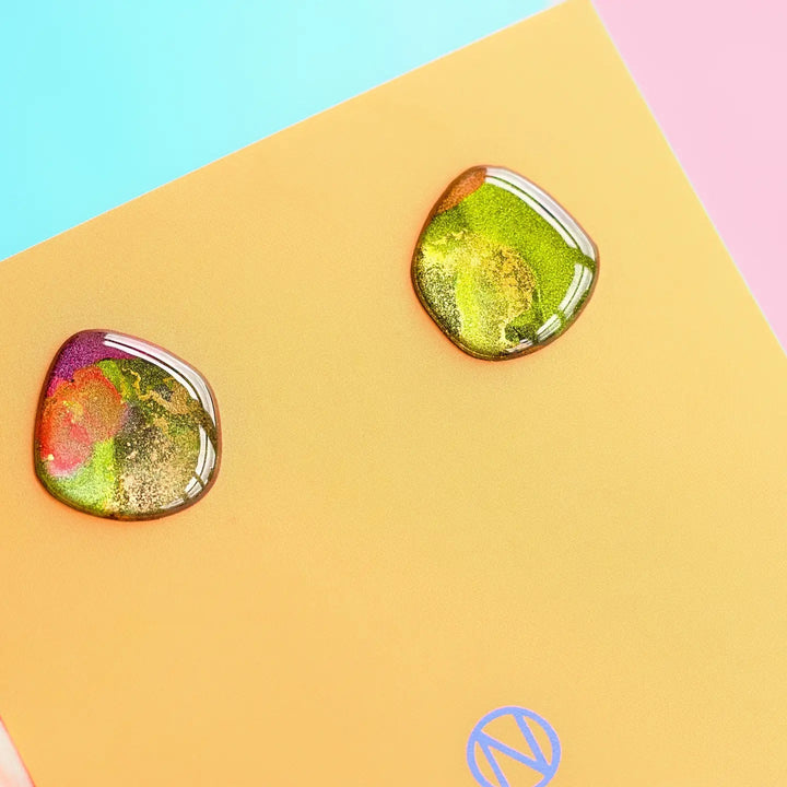 Two drops of water on a piece of Naoi Aurora Stud Earrings.