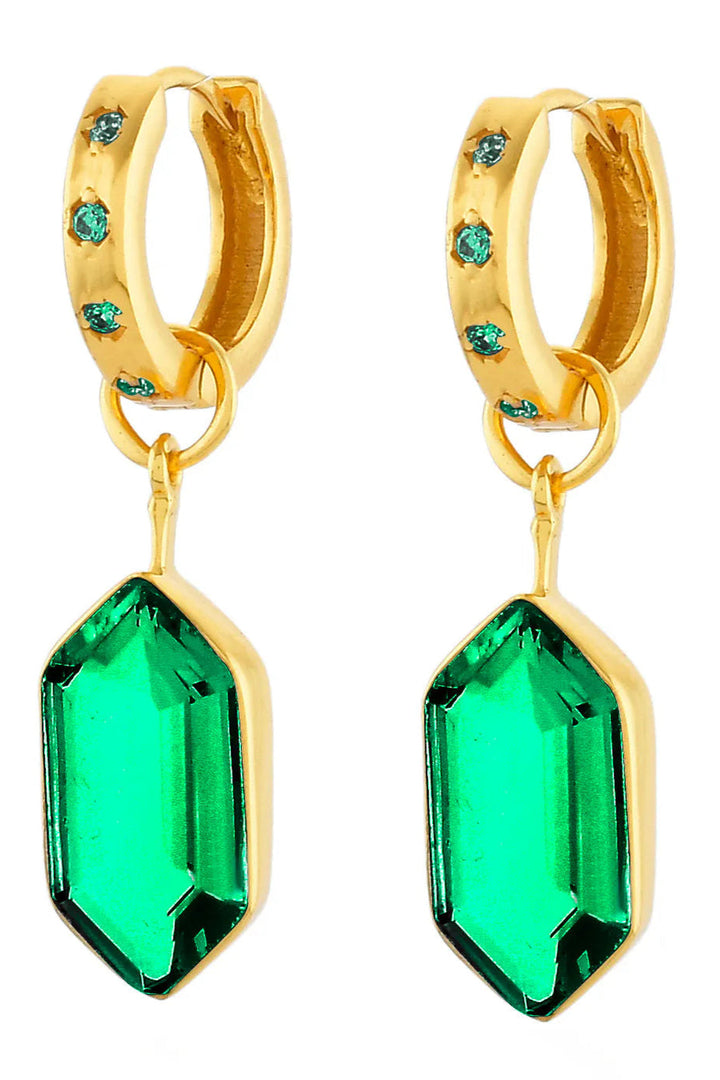 A pair of gold huggie hoop earrings with small green gemstone accents on the hoops and large faceted green gemstone dangles, shown on a plain white background.