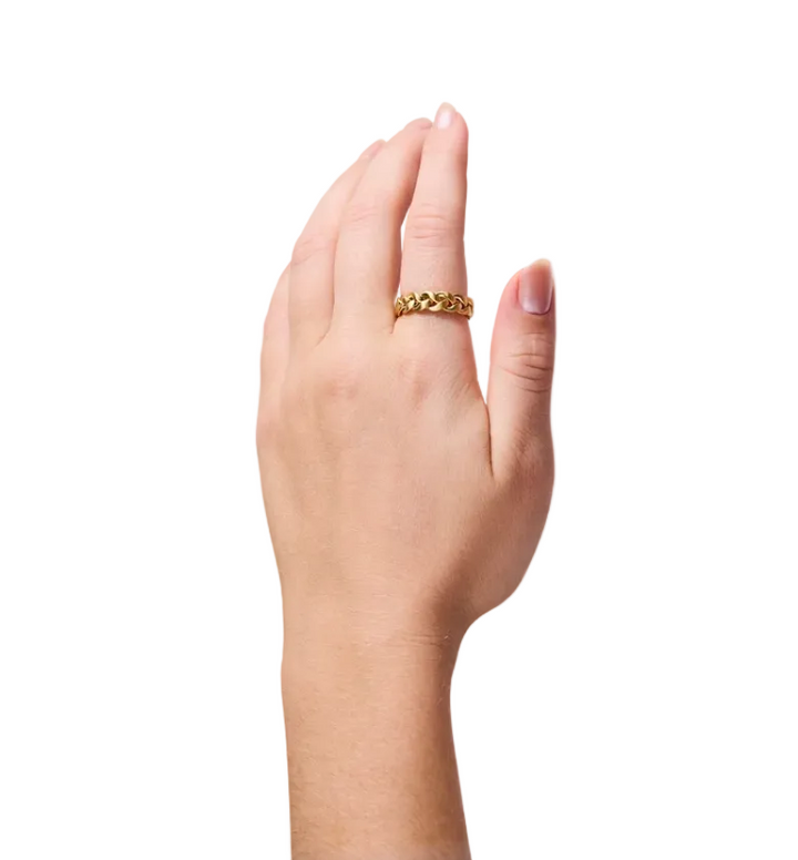 A close-up of a person's hand wearing a textured gold ring, set against a solid white background.