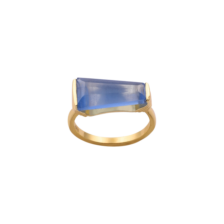 A Blue Quartz Gold Ring by Watermelon Tropical featuring a large, rectangular blue quartz gemstone. The gemstone is set horizontally and has a smooth, flat surface with pointed ends. The ring band is simple and polished, enhancing the focus on the striking gemstone, exemplifying exquisite handmade jewellery design.