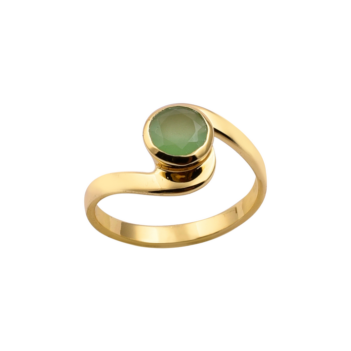The Chrysophrase Chalcedony Gold Ring by Watermelon Tropical features a unique, curved band design and a single, oval-shaped green chrysoprase chalcedony gemstone set at the top. The faceted gemstone enhances its reflective qualities. The ring's elegant and contemporary style highlights the vibrant green of the stone, emphasizing exquisite handmade jewellery craftsmanship.