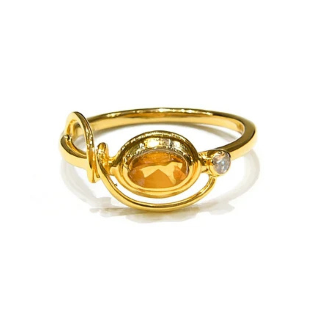 The Watermelon tropical Citrine & Cubic Zirconia Gold Ring features a gold-plated sterling silver band with an oval citrine center and a clear cubic zirconia accent, designed like a planetary orbit. Shown on a white background.