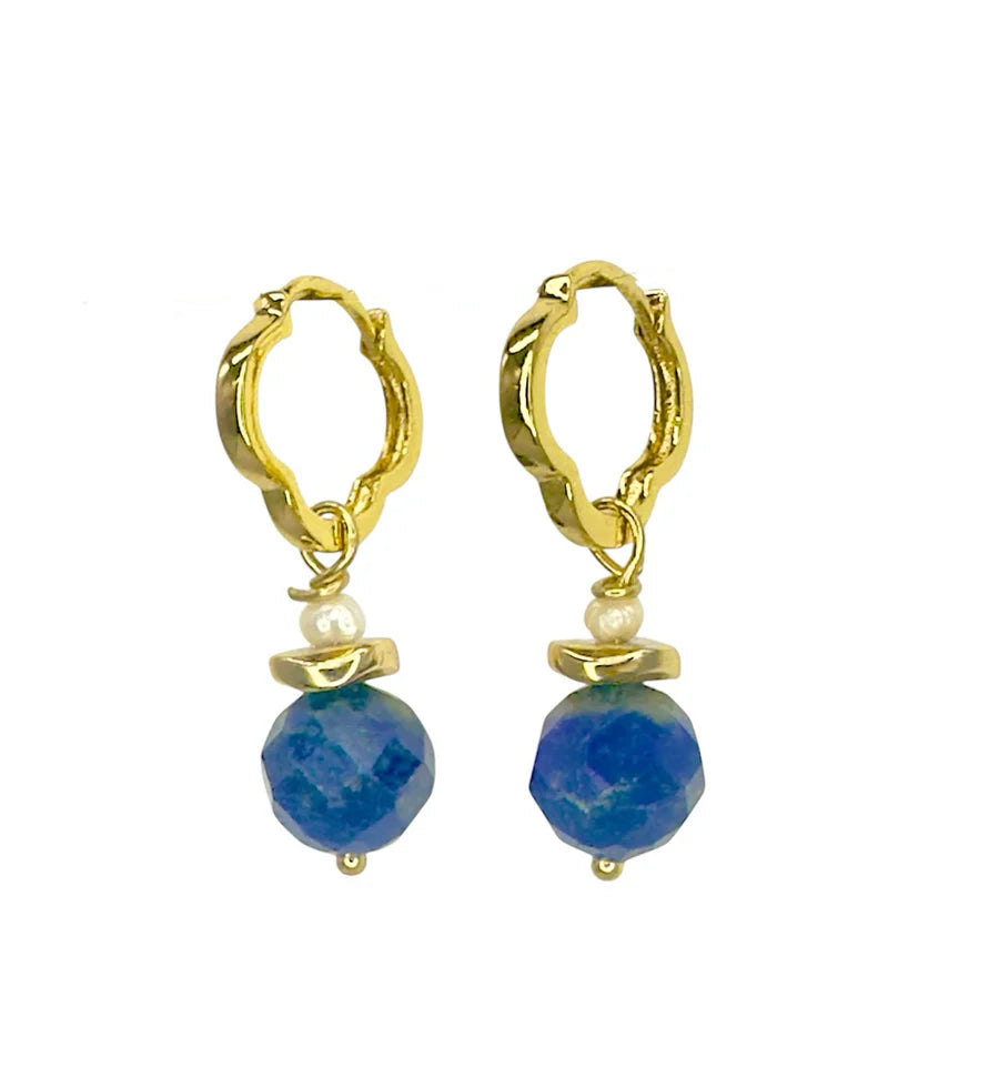 Aria V Clover Lapis Earrings: gold hoops with a small white pearl and faceted blue bead dangle, handmade in Ireland and inspired by lapis lazuli jewelry, shown on a white background.