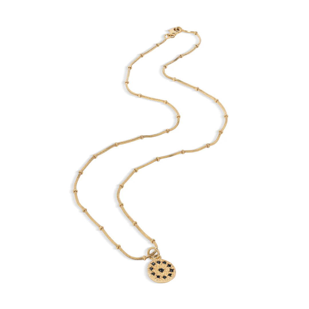Gold necklace with a round pendant on a white background.