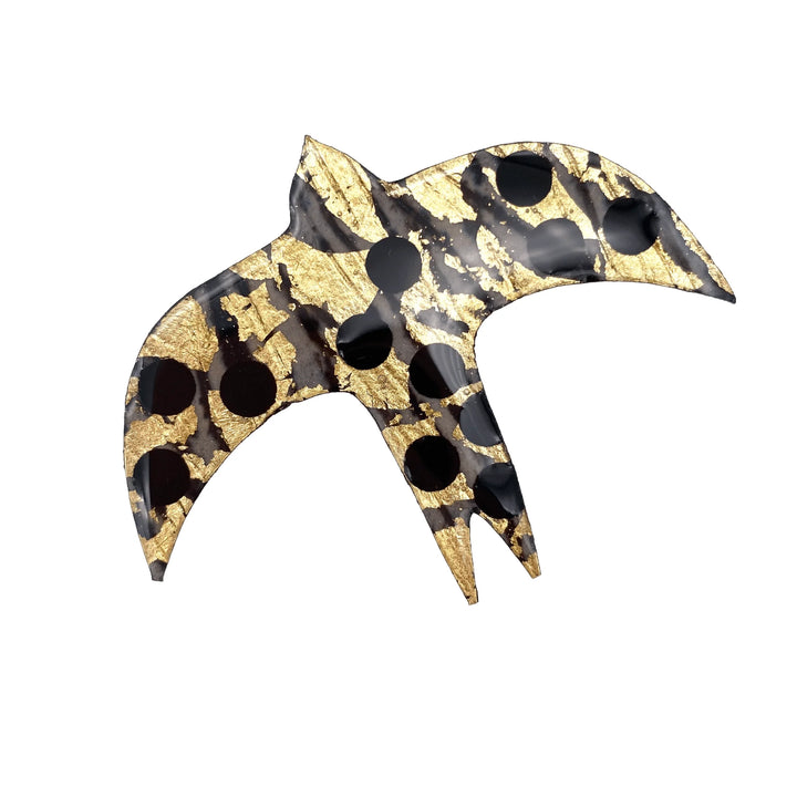 The Rothlú Éan Bird Batik Textile Brooch features a black and gold batik pattern with gold leaf accents and black circular spots, presented on a white background.