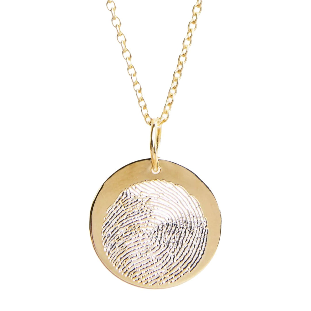 Personalised Charms' Engraved Fingerprint Pendant is a gold necklace with a round disc featuring a customized design, elegantly hanging on a delicate chain.