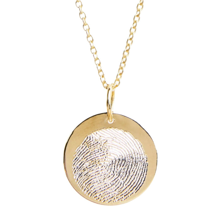 Personalised Charms' Engraved Fingerprint Pendant is a gold necklace with a round disc featuring a customized design, elegantly hanging on a delicate chain.