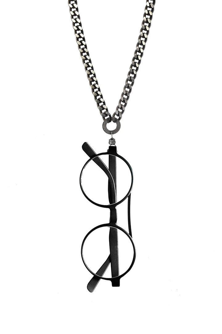 A smart necklace featuring a silver, adjustable chain with round-rimmed glasses hanging vertically from it. The temples are folded inward, and the thick metallic chain contrasts beautifully with the delicate design of the glasses. This is the EyesOnOff Eyewear Burnished Chain by AnnaeAlex. The background is white.