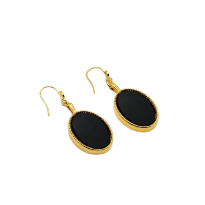 Introducing the Frida Earrings by Nilai, featuring natural oval-shaped black stones at the center of dangling 24K gold-finished pieces. Handmade in Paris, these exquisite earrings employ hook-style clasps for attaching to pierced ears.