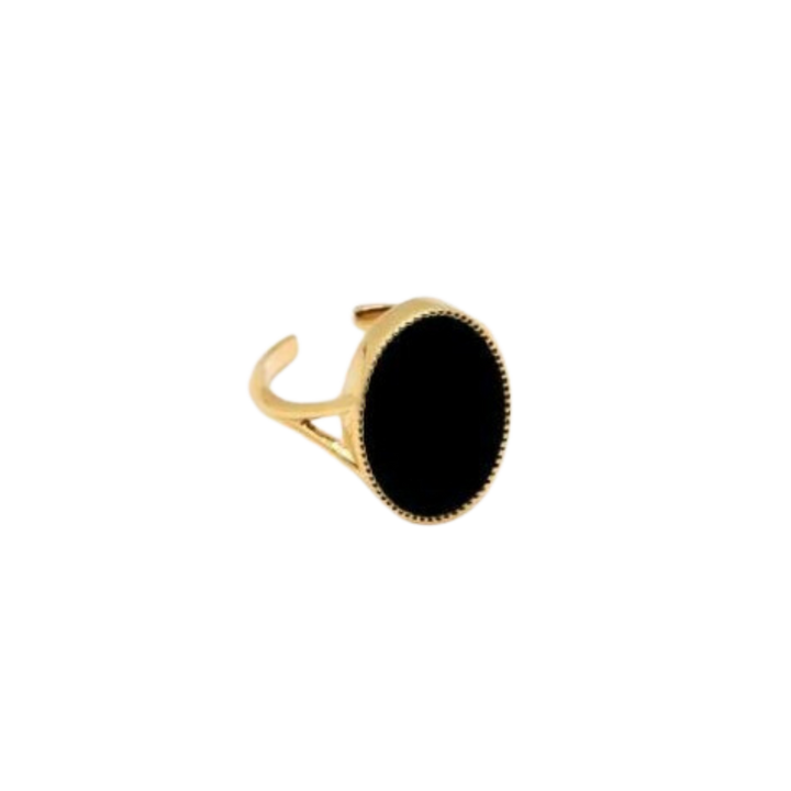 The Frida Ring by Nilai features a gold band with a large, oval-shaped black natural stone at its center. Its minimalist design boasts clean lines and an adjustable band for a perfect fit.